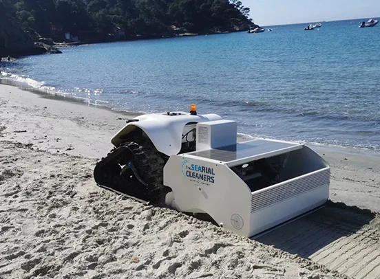 The robot parked at the shoreline of a turquoise cove