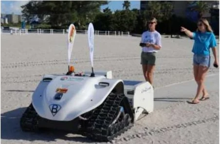 Operator driving the robot by remote control at a public beach demonstration