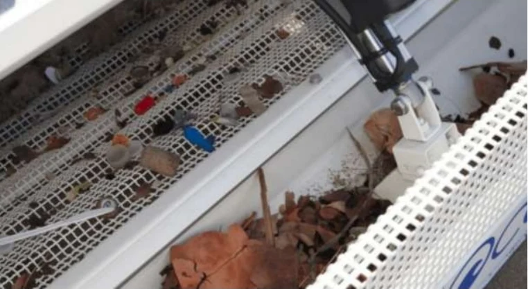 Plastic caps, glass and debris collected in the robot's sifting tray